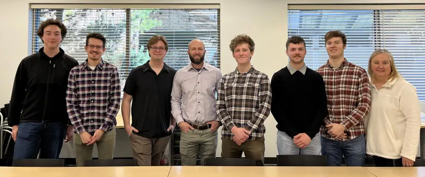 Photo of our senior design project sponsor, me, and my teammate, Shayne M. at our second release at DMSi HQ, December 9th, 2023.